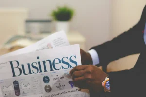 Persona sosteniendo el periodico en la sección de negocio buscando como hacer apalancamiento inmobiliario