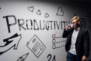 Profesional inmobiliario, construyendo su marca personal en oficina con mural con escrito productivity