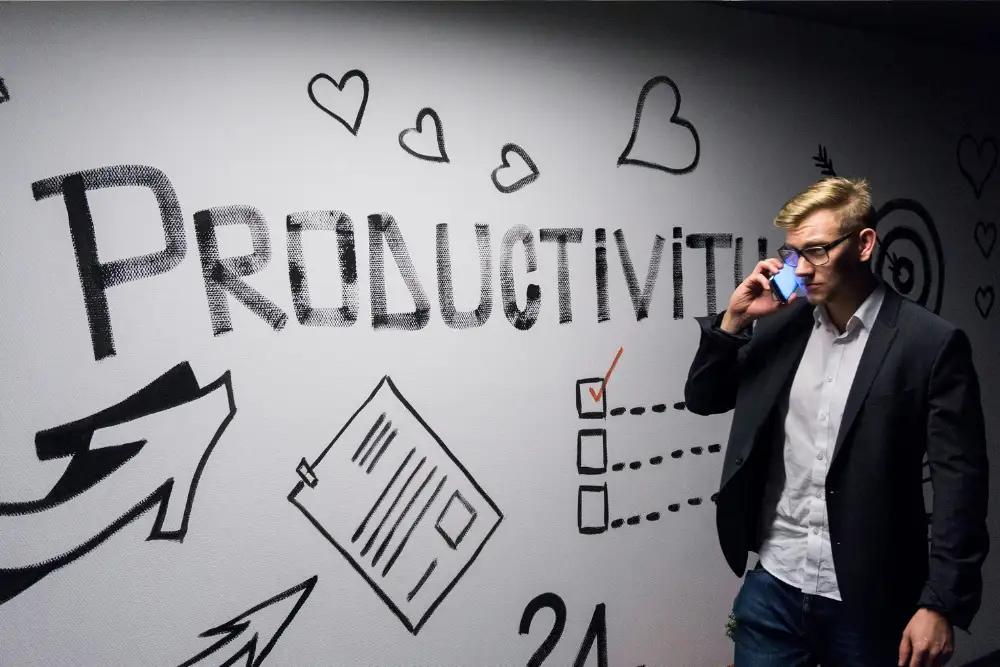 Profesional inmobiliario, construyendo su marca personal en oficina con mural con escrito productivity