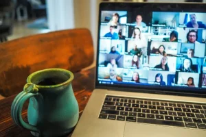 Pantalla de computadora con reunión digital de un broker haciendo networking inmobiliario