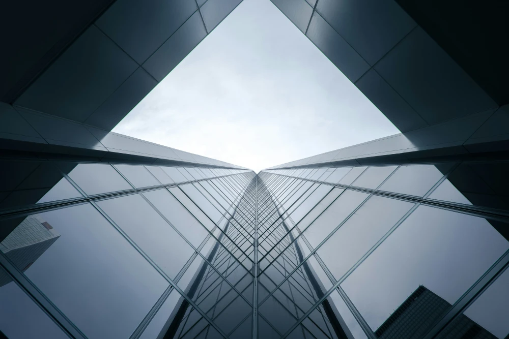 vista desde la base de un edificio moderno con ventanas de cristal para opciones de financiamiento inmobiliario alternativo