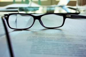 Anteojos sobre un contrato, haciendo referencia a la auditoria lega len la compra de propiedades