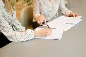 Personas firmando un contrato haciendo referencia a los reglamentos de copropiedad