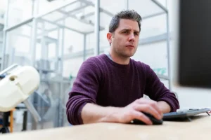 Hombre sentado en su pc gestionando arriendo en su software de gestión de arriendos